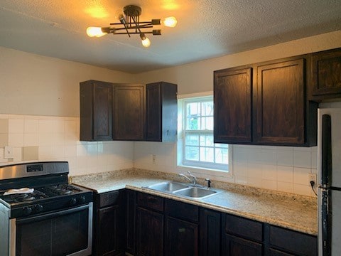 kitchen featuring appliances with stainless steel finishes, decorative backsplash, dark brown cabinetry, and sink