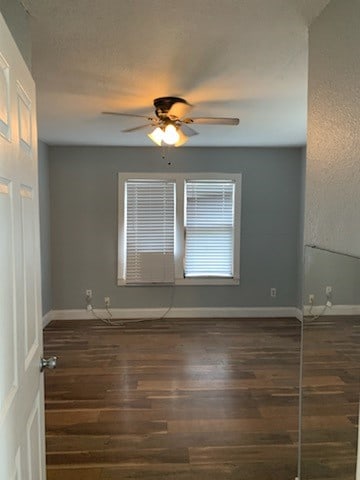 unfurnished room with dark wood-type flooring and ceiling fan