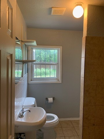 bathroom featuring tile patterned flooring, toilet, and sink