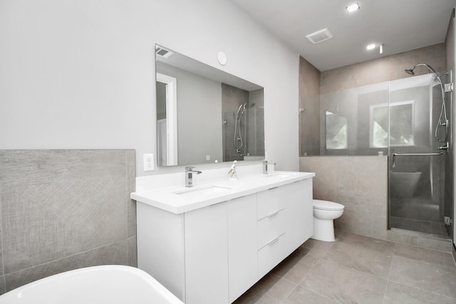 full bathroom with toilet, shower with separate bathtub, tile walls, vanity, and tile patterned flooring