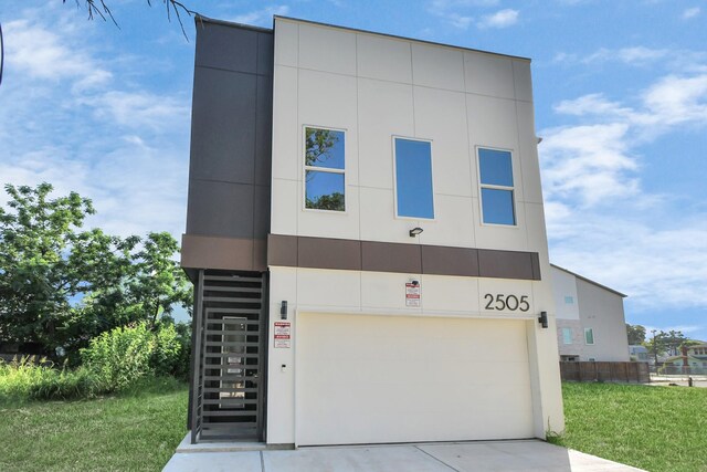 contemporary home featuring a front lawn and a garage