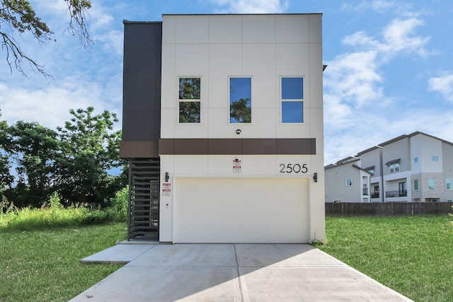 modern home featuring a garage and a front lawn