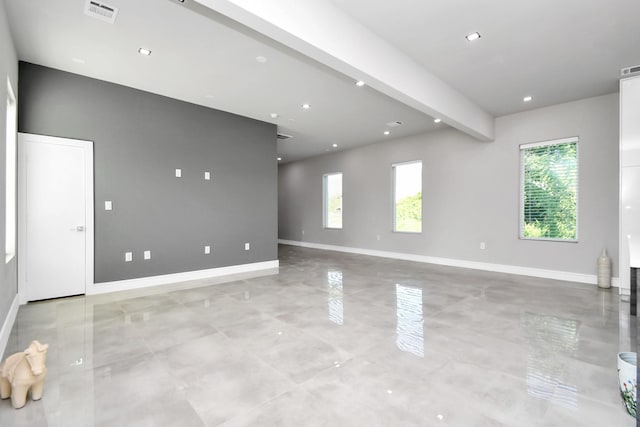 spare room with a healthy amount of sunlight and beam ceiling