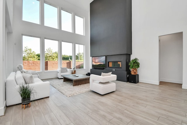 living room featuring a towering ceiling and light wood-type flooring