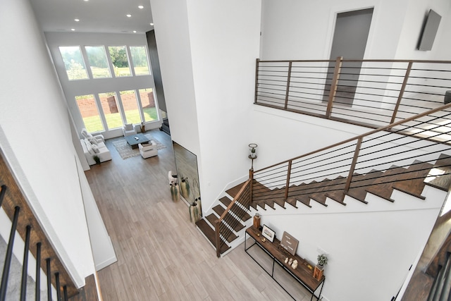 staircase featuring hardwood / wood-style floors and a high ceiling