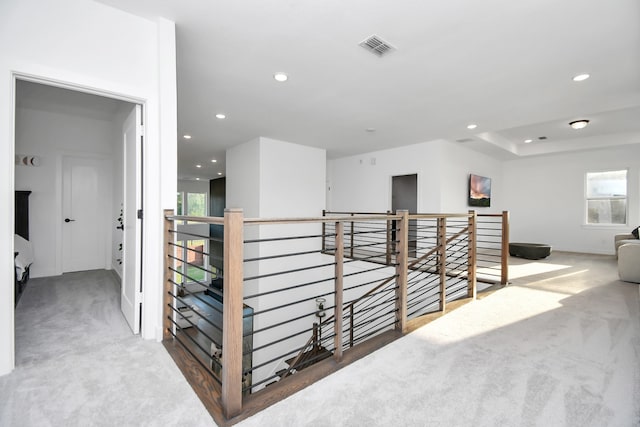 hallway with a wealth of natural light and carpet floors