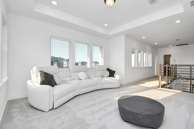 carpeted living room featuring a raised ceiling