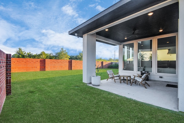 view of yard featuring a patio area and ceiling fan