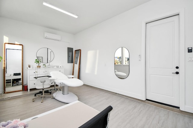 office featuring electric panel, baseboards, wood finished floors, and a wall unit AC