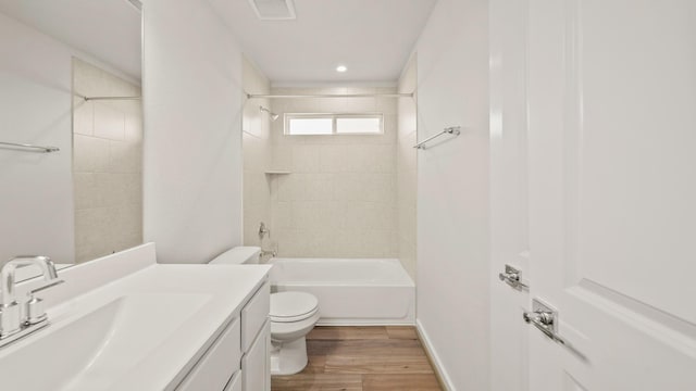 full bathroom with hardwood / wood-style flooring, vanity, toilet, and tiled shower / bath