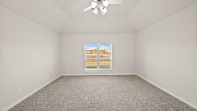 carpeted spare room with ceiling fan and vaulted ceiling