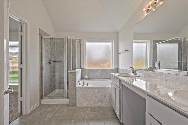 bathroom with vanity, vaulted ceiling, and separate shower and tub