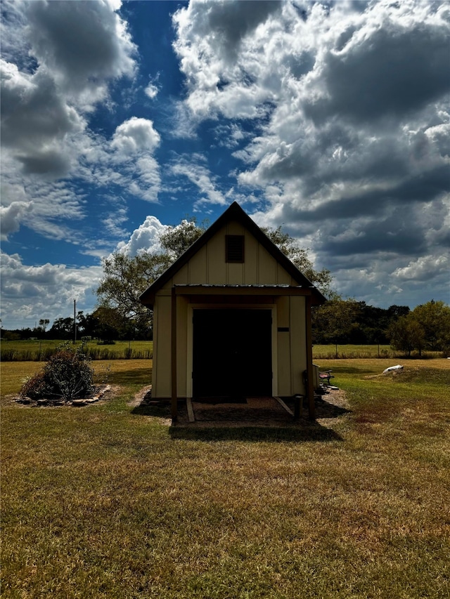 view of outbuilding featuring a yard and a rural view