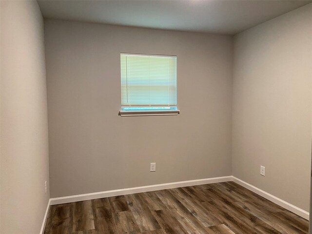 unfurnished room featuring dark wood-type flooring