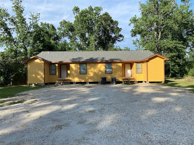 ranch-style home featuring entry steps and a shingled roof