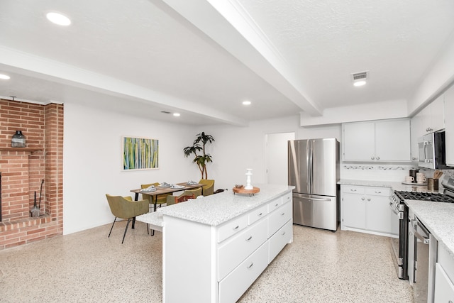 kitchen featuring a center island, white cabinetry, stainless steel appliances, and a textured ceiling