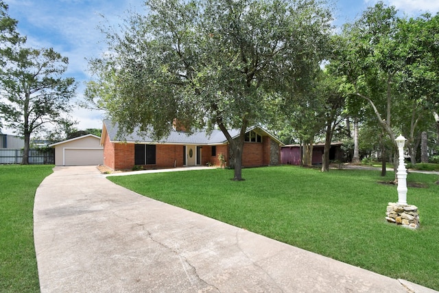 single story home featuring brick siding, a front lawn, fence, a garage, and an outdoor structure