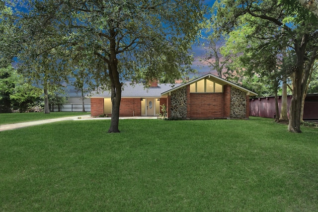 mid-century modern home with a front lawn, fence, brick siding, and a chimney