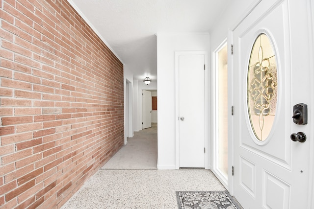 entryway featuring brick wall