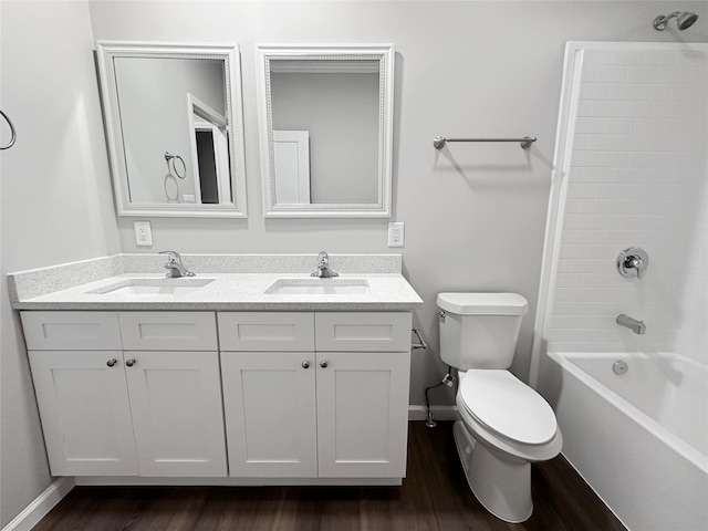 full bathroom featuring toilet, hardwood / wood-style floors, double vanity, and shower / bathtub combination