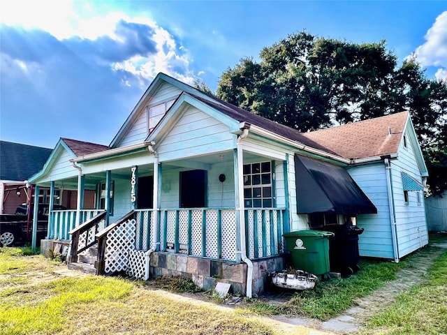 view of front facade featuring covered porch and roof with shingles