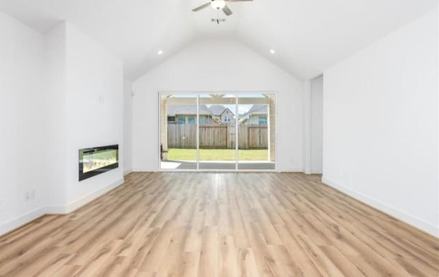 unfurnished living room featuring a ceiling fan, baseboards, light wood finished floors, lofted ceiling, and a glass covered fireplace