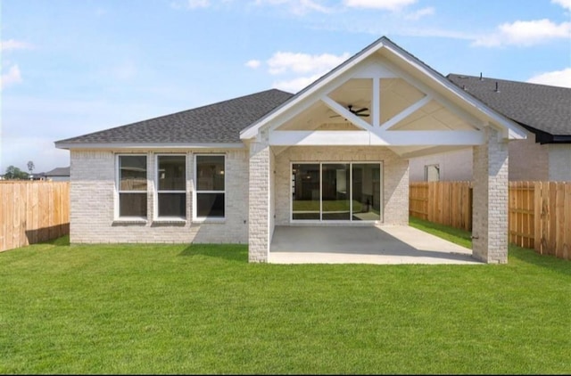 back of property with a fenced backyard, a yard, a patio area, and brick siding