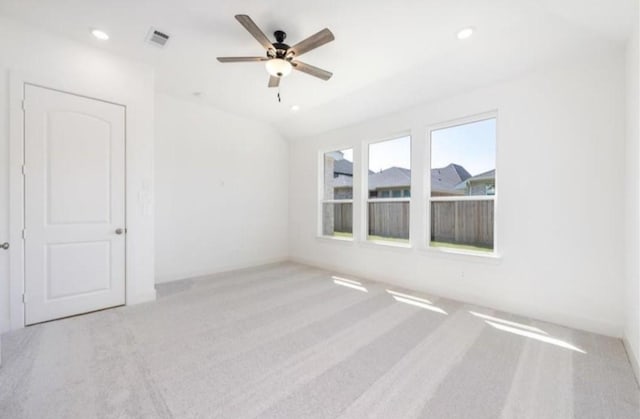 spare room with a ceiling fan, visible vents, vaulted ceiling, carpet, and recessed lighting