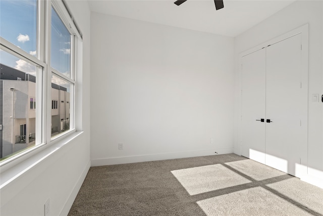 carpeted spare room featuring ceiling fan