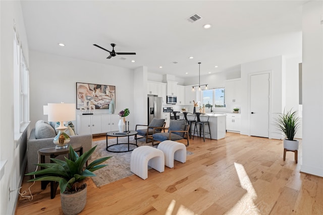 living room featuring ceiling fan and light wood-type flooring