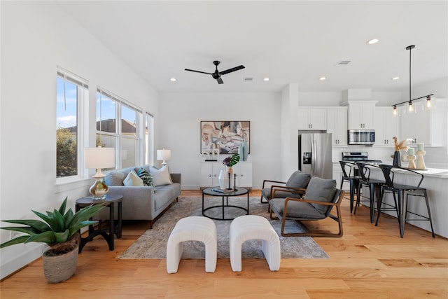 living room with ceiling fan and light hardwood / wood-style floors