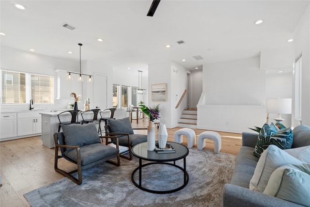 living room featuring a chandelier and light wood-type flooring