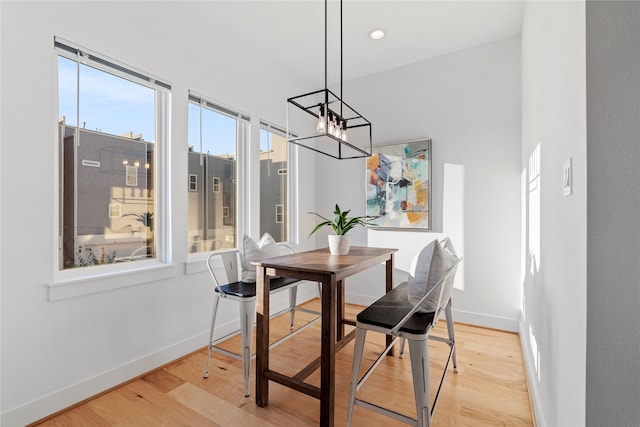 dining area featuring light hardwood / wood-style flooring and a chandelier