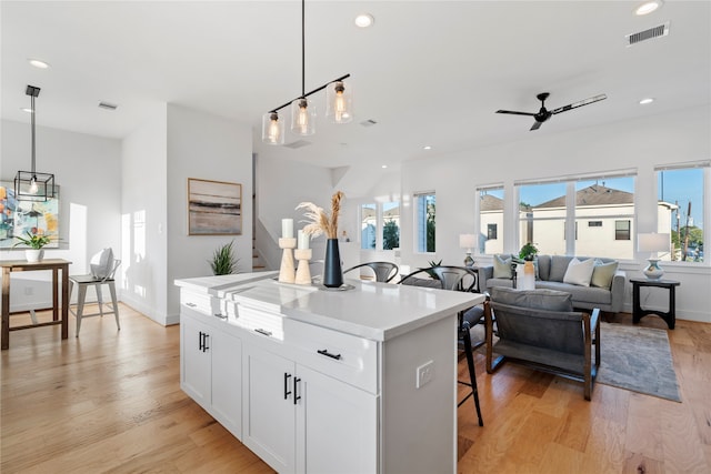 kitchen with white cabinetry, pendant lighting, and light wood-type flooring