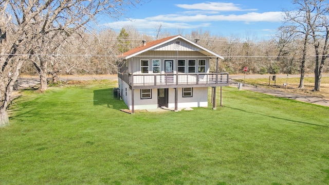 rear view of house with central air condition unit, a lawn, and a wooden deck