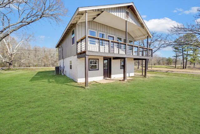 back of property featuring a lawn and central air condition unit