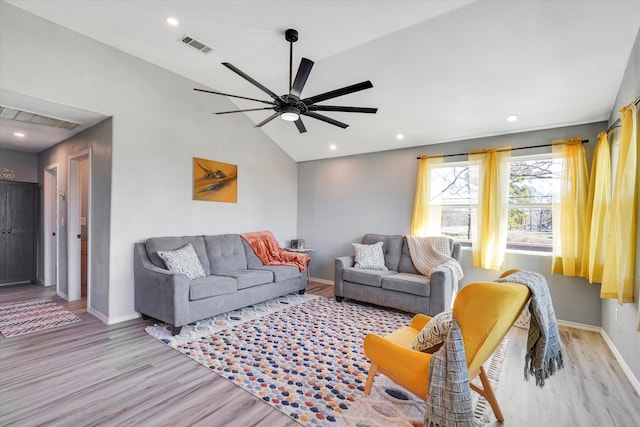 living room with ceiling fan, vaulted ceiling, and light hardwood / wood-style floors