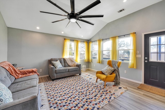 living room with a wealth of natural light, ceiling fan, light wood-type flooring, and lofted ceiling