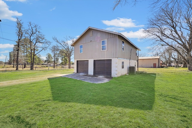 view of property exterior featuring a garage, a lawn, and central AC unit