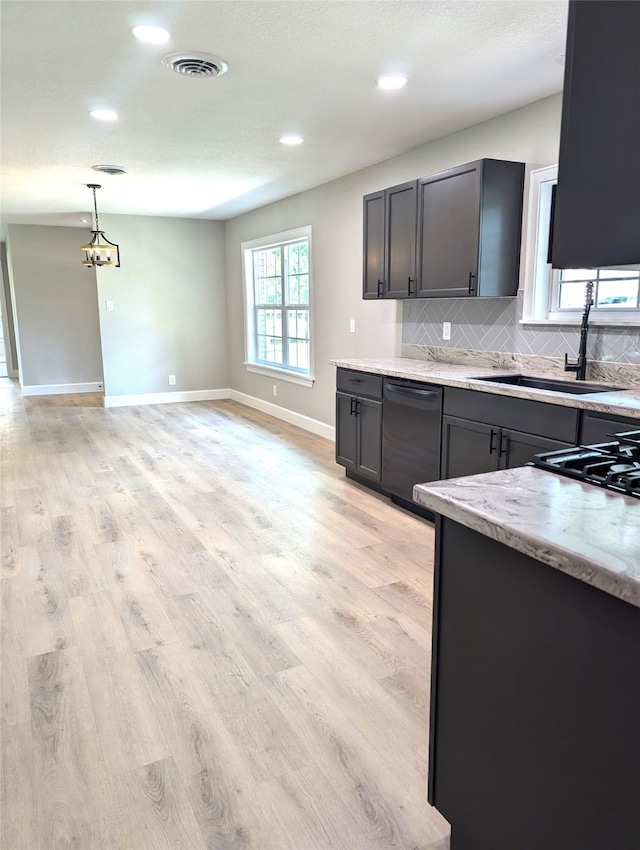 kitchen with light hardwood / wood-style flooring, black dishwasher, sink, and light stone counters