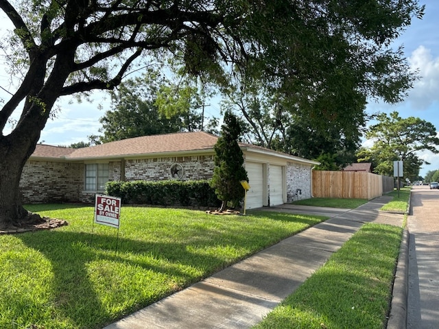 single story home with a garage and a front yard