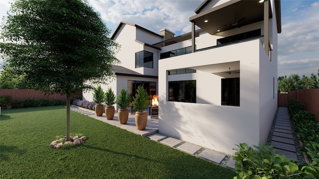 rear view of house with ceiling fan, a yard, and a patio