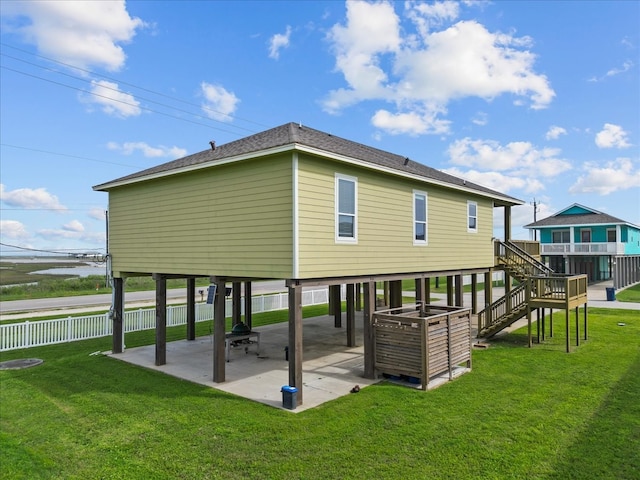 rear view of property with a water view, a yard, and a patio area