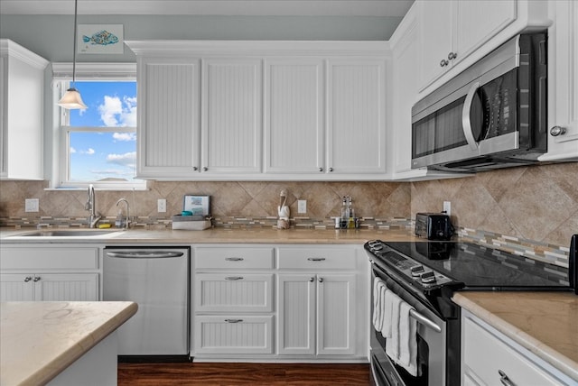 kitchen featuring pendant lighting, tasteful backsplash, stainless steel appliances, dark hardwood / wood-style flooring, and sink