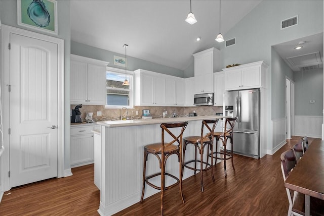 119 Velasco Shores Dr, Surfside Beach, TX 77541 - kitchen with stainless steel appliances, dark wood-style floors, a center island, lofted ceiling, and decorative backsplash