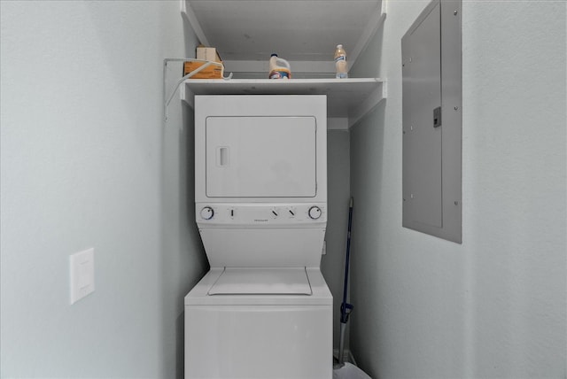 washroom featuring stacked washer and clothes dryer and electric panel