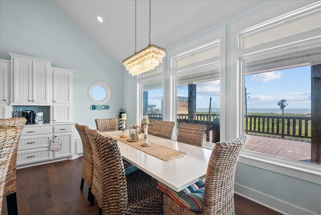 dining space with high vaulted ceiling, a chandelier, a water view, and dark hardwood / wood-style floors