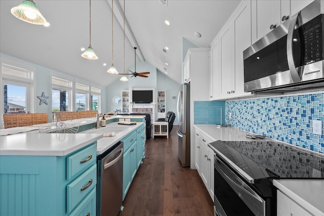 kitchen featuring white cabinets, decorative light fixtures, appliances with stainless steel finishes, dark wood-type flooring, and decorative backsplash