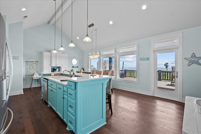 kitchen featuring a kitchen island with sink, dark hardwood / wood-style flooring, hanging light fixtures, and blue cabinetry