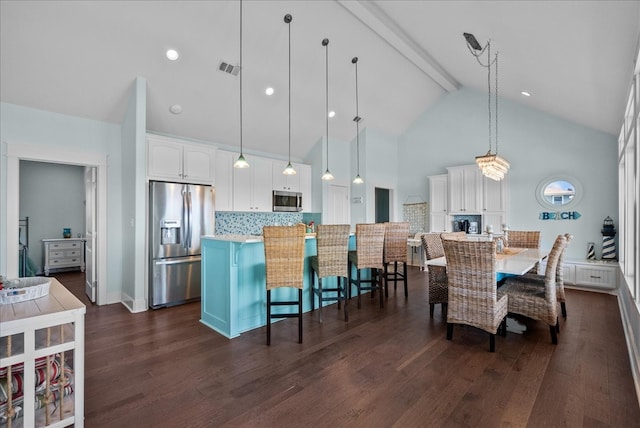 kitchen featuring pendant lighting, stainless steel appliances, tasteful backsplash, and white cabinetry